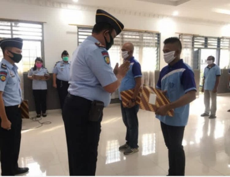 Kepala Lapas Klas II B Kota Tebingtinggi Theo Andreanus Purba menyerahkan remisi kepada salah satu warga binaan.