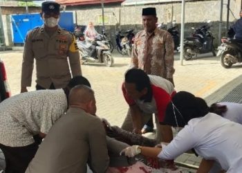 Petugas medis dibantu personil polisi saat memberikan perawatan kepada korban pembacokan.(f:ist/konstruktif)